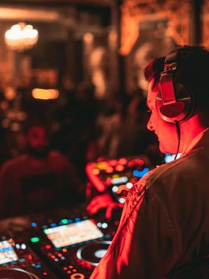 A side profile from the same gig, showing the view from behind the decks looking out onto the blurred crowd.