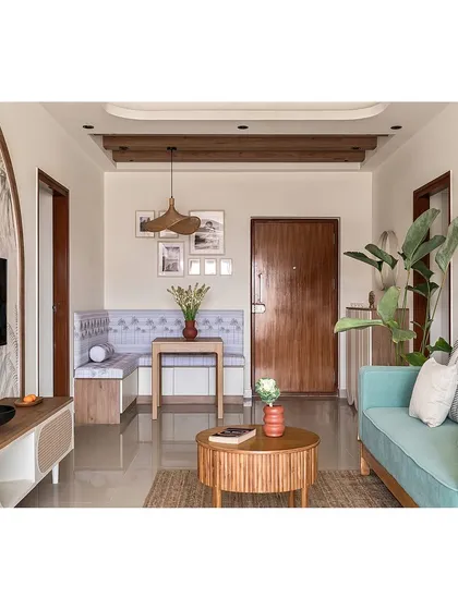 I designed this open-plan living and dining area to be a serene, bohemian-inspired oasis. The layout maximizes space and light, featuring a custom L-shaped dining bench and a mint green sofa for a fresh, inviting feel.