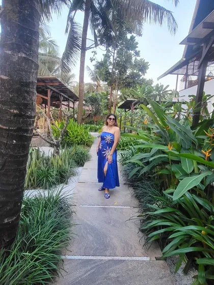 A full-length shot of the blue strapless dress in a beautiful tropical setting.