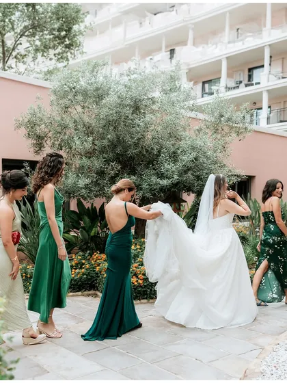 A bridesmaid helps the bride with her veil. It's these acts of love and support that define the bond of a bride tribe.
