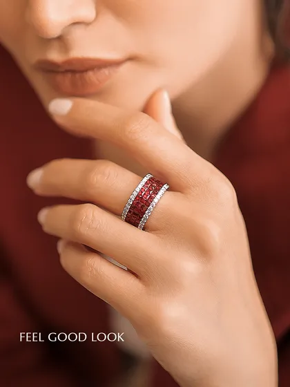 This is what I call a "feel good look." A woman's hand elegantly displays a wide band ring with three rows of channel-set rubies, flanked by rows of brilliant diamonds. The rich color and sparkle are designed to bring confidence and joy.