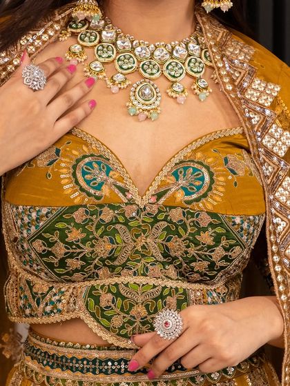 A close-up of the exquisite blouse from our mustard and green lehenga set. The intricate embroidery and sweetheart neckline are complemented perfectly by the rental jewellery set.