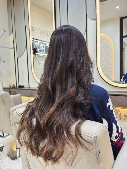 An elegant and subtle balayage on long, dark hair. The lighter ends create a beautiful, understated gradient effect.