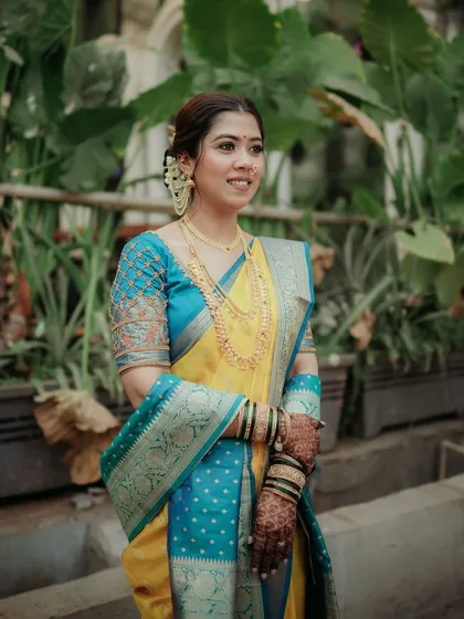 A full-length portrait of the bride in her beautiful yellow and blue saree.