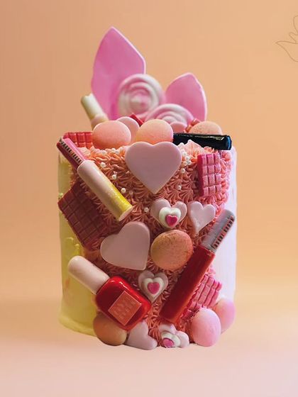 A beauty lover's dream cake, adorned with edible makeup items like lipstick, nail polish, and chocolate bars. It's a glamorous and sweet treat.
