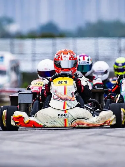 A tight formation of karts heading into the first corner.