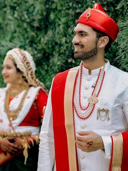 Another beautiful portrait of the Marathi couple, with the groom looking ahead while the bride stands softly in the background. It’s a serene and elegant composition.