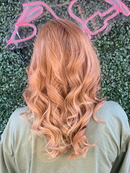 A beautiful rose-gold global hair color. This unique shade is a blend of blonde and pink tones, creating a warm and fashionable look, seen here from the back.