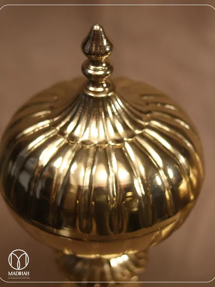 A close-up of the Mughal Gold Jar's lid, showing the intricate fluting and classic finial. These details are inspired by the grandeur of Mughal art and architecture.