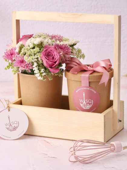 My dessert and flower hamper is a complete gift. It pairs a delicious dessert cup with a fresh bouquet of pink flowers in a charming wooden caddy.