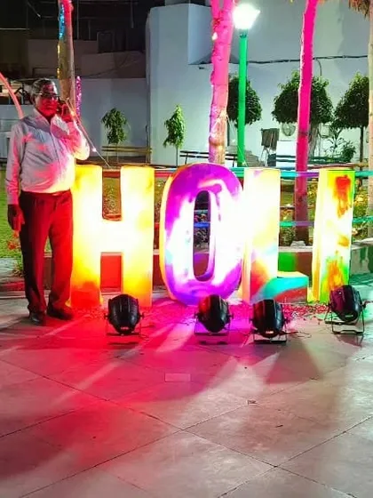 I can provide large, custom props for your event. This is a large light-up 'HOLI' sign I set up for a Holi festival party, complete with spotlights to make it stand out at night.