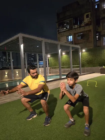 The squat is a foundational movement for generating power. Our coach demonstrates the correct form, teaching the young athlete how to engage his legs and core for more powerful shots and faster sprints.