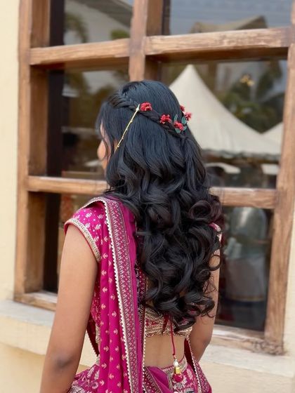 A close-up of the half-updo with a braided crown and delicate red flowers.