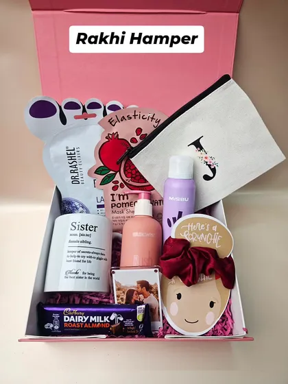 A Rakhi hamper designed to pamper your sister. This gift box includes everything she loves: Dr. Rashel skincare, a personalized initial pouch, a "Sister" mug, and of course, some Dairy Milk chocolate. It’s a box full of love for your partner in crime.
