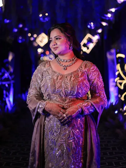 A beautiful candid shot of the bride under dramatic blue lighting, her makeup looking perfect.