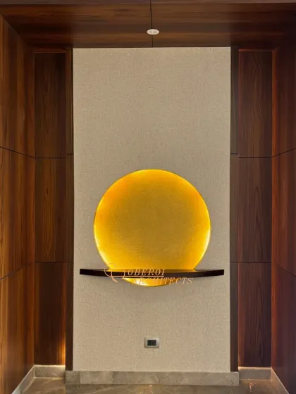 A close-up of the art niche, where a simple circular light fixture illuminates a small shelf, turning a small space into a point of interest.