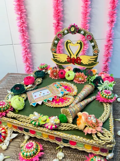 Elevate your Mehendi ceremony with this stunning platter. The design features a rich green base, a swan couple motif symbolizing love, and a vibrant array of handcrafted flowers for a touch of artistry.