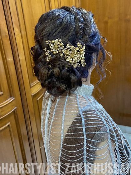 A beautiful example of a braided updo for a wedding guest. The intricate braids are woven into a low bun and accented with jeweled clips for a touch of glamour.