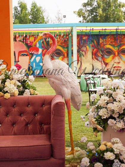 A detail from our Carnival theme decor, featuring a quirky flamingo prop next to a plush pink sofa, set against a backdrop of colorful graffiti art.