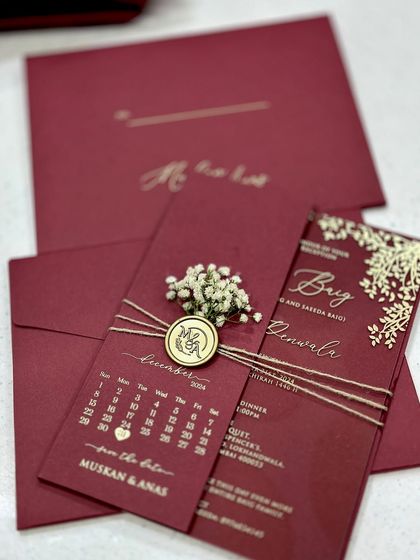 A beautiful acrylic wedding invitation in a rich maroon, designed based on the bride's vision. The card includes a save-the-date calendar and is finished with a wax seal and dried flowers.