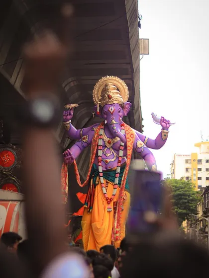 A unique purple Ganesh idol being celebrated by devotees, showcasing the variety and creativity seen across different pandals.