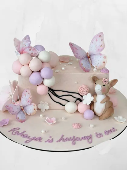 Halfway to one! This sweet cake for Rehaya celebrates her six-month milestone with pastel balloons, butterflies, and a cute little kangaroo.