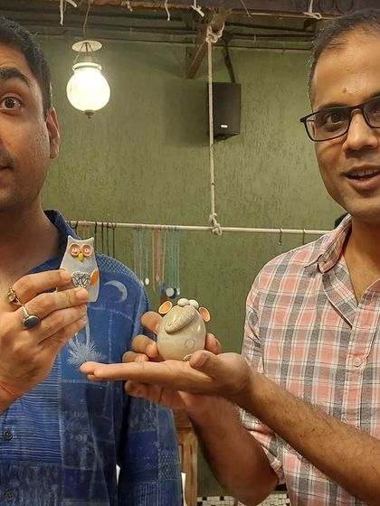 Two friends picking out their favorite miniature animal figurines at my market stall. I make owls, mice, and other small creatures that are perfect for collecting.