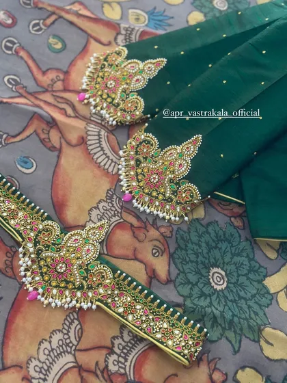 Exquisite temple jewellery embroidery on a dark green blouse, featuring multi-colored stones and pearl details.