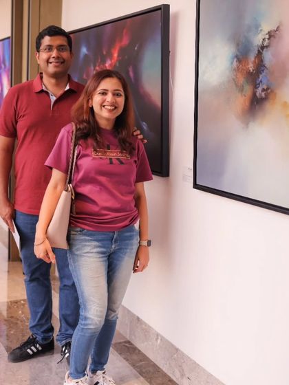 A couple enjoying the 'Mystic Mirage' exhibition, taking in the large-scale abstract canvases.