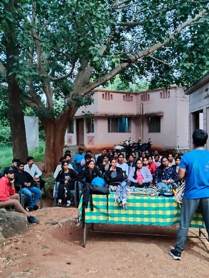 An evening session at the Ramanagara campsite, where participants gather to share their experiences from the day and learn new skills.