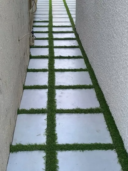 This project shows a creative use of artificial grass in a narrow side yard. I installed synthetic turf between large concrete pavers to create a unique and visually interesting walkway that is both functional and green.