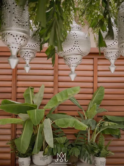 A detail shot of the hanging Moroccan-style silver lanterns, which add a touch of intricate, handcrafted beauty to the simple green and white theme.