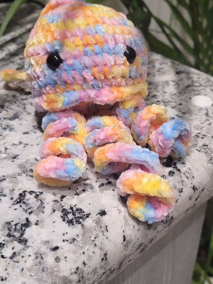My first baby jellyfish sitting on a countertop, showing off its cute, curly tentacles. Each one is handmade and has its own little personality.