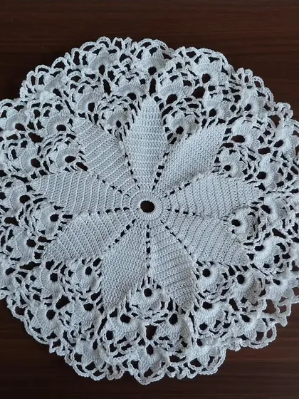 An intricate 15-inch crochet doily, perfect as a centerpiece for a table or as the base for a large, custom dreamcatcher. The detailed floral pattern is a classic design that adds a touch of vintage charm to any space.
