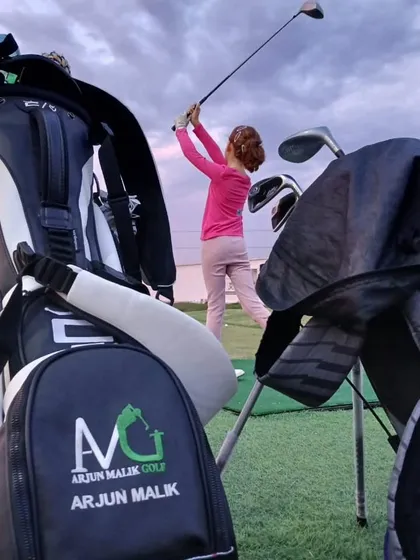 A young girl perfects her swing against a beautiful evening sky. We aim to make golf an inspiring and enjoyable sport for the next generation of players.