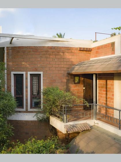 A view of the upper floor balcony and the flat roof section, showing the different levels and textures of the exterior.