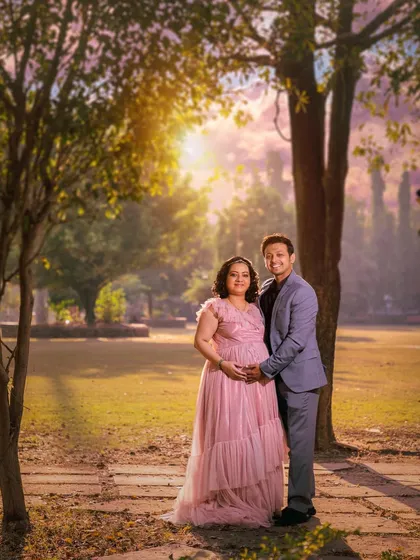 An outdoor maternity session for an expecting couple, using the beautiful golden hour light in a park setting. This style is perfect for capturing the warmth and anticipation of your journey to parenthood.