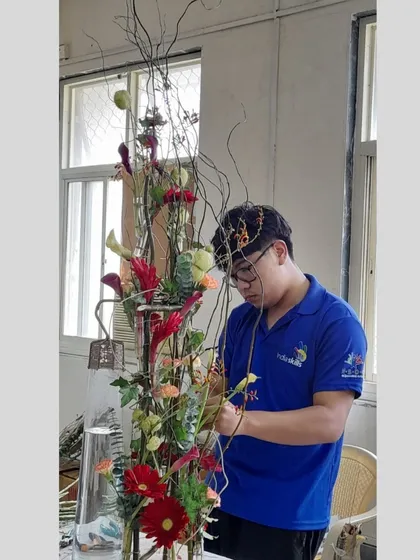 Maximus, our WorldSkills competitor, is seen here perfecting a large, complex arrangement during his intensive training at our institute. We prepare our students for the highest levels of competition.
