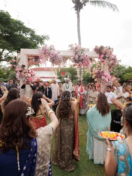 The groom's grand welcome. The bride's family lines the path, ready to shower the groom with flowers in a beautifully choreographed entry sequence.