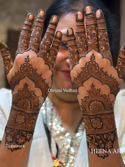 A lovely client showing off her intricate back-hand mehendi with beautiful scalloped borders.
