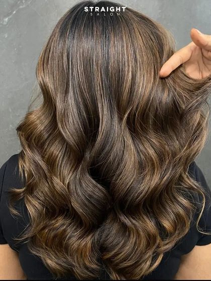 A stylist's hand running through the hair, showing its softness and movement.