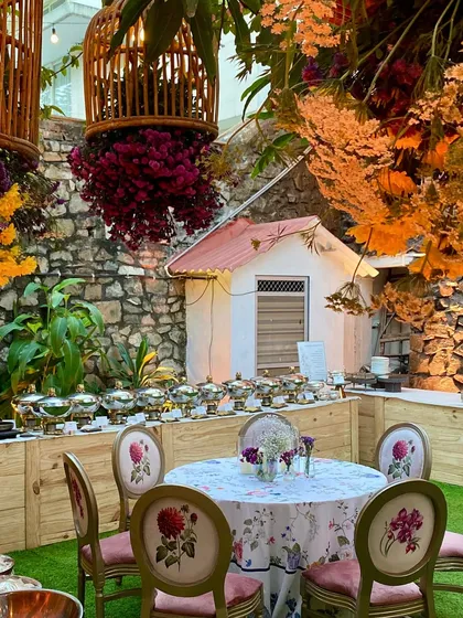 A stunning outdoor buffet setup for a 50th-anniversary party, with the food station nestled amongst beautiful floral decor.