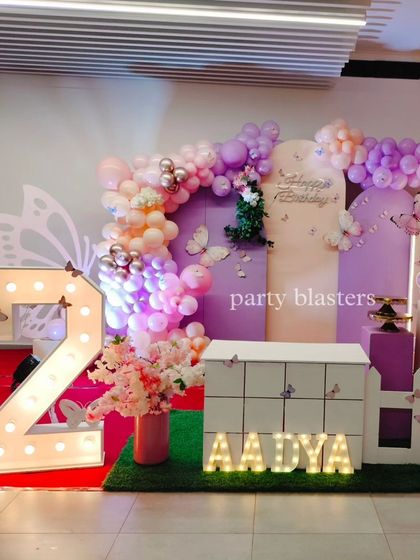 The full view of Aadya's butterfly-themed dessert and cake station, designed with a custom table, backdrops, and balloon arches.