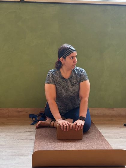 Yoga is for everyone. A member uses a block for support, demonstrating our inclusive approach to practice.