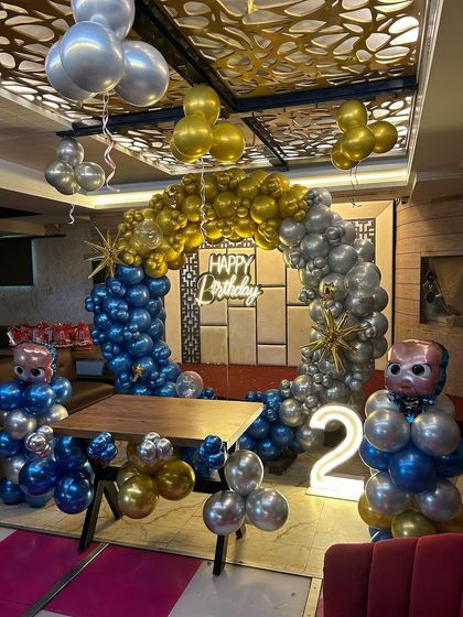 The boss is in! This fun Boss Baby theme was for a 2nd birthday party. The setup included a balloon arch in blue, gold, and silver, character balloon sculptures, and a light-up number '2' for the little boss's big day.