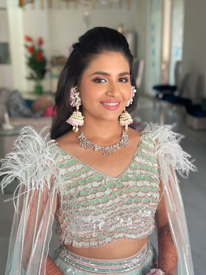 This portrait shows how the makeup ties in with the unique floral and jhumka earrings, creating a cohesive and stylish Mehendi look.