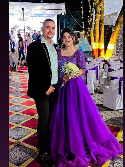 A happy couple celebrating their engagement. The bride-to-be is wearing a vibrant purple ball gown, looking like a true princess.