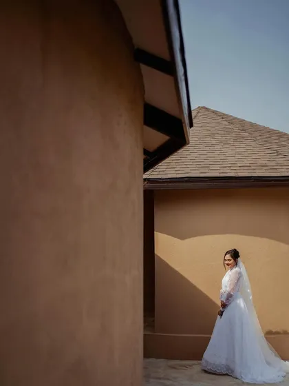 A simple yet elegant bridal portrait. The clean lines of the architecture and the play of light and shadow create a serene and modern feel.