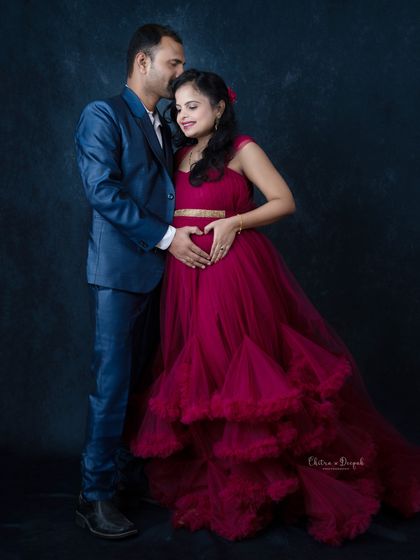 A formal and romantic portrait. The dad-to-be's gentle kiss on her forehead is a beautiful expression of love and care.