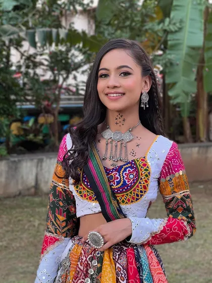 A full look of this client ready for Navratri, with a multi-colored lehenga and a fresh, minimal makeup look.